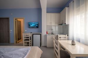 a room with a bed and a kitchen with blue walls at Villa Kale in Sarandë
