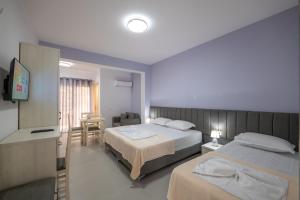 a hotel room with two beds and a television at Villa Kale in Sarandë