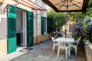 a patio with a table and chairs and an umbrella at Varazze Apartment in Varazze