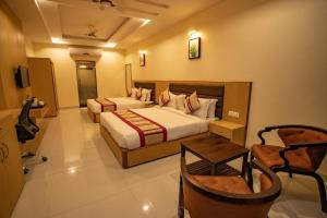 a hotel room with two beds and a table at Hotel Aarunya Royale in Jodhpur