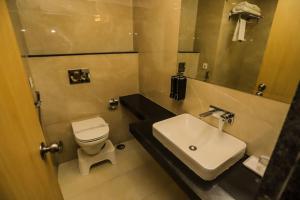 a bathroom with a white toilet and a sink at Hotel Aarunya Royale in Jodhpur