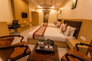a hotel room with a bed and a table and chairs at Hotel Aarunya Royale in Jodhpur