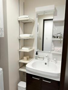 a bathroom with a sink and a mirror and a toilet at PRIME TREE Izumizaki CONDO HOTEL in Naha +39 photos