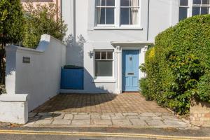 a white house with a blue door on a street at Cliffhanger 18 Castle Road in Cowes