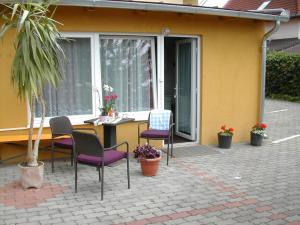 a patio with chairs and a table in front of a building at Orchidea Apartman in Hévíz