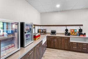 a large kitchen with wooden cabinets and a refrigerator at Hampton Inn Knoxville-Airport in Alcoa