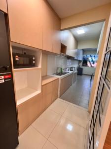 a small kitchen with white cabinets and a hallway at Hermosa Homestay in Lahad Datu