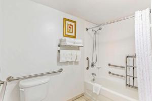 a bathroom with a shower and a toilet and a tub at Comfort Suites Longmont in Longmont