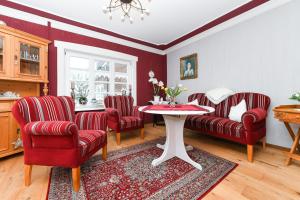 ein Wohnzimmer mit roten Stühlen und einem Tisch in der Unterkunft Ferienwohnungen im Haus Hafenjuwel in Neuharlingersiel in Neuharlingersiel