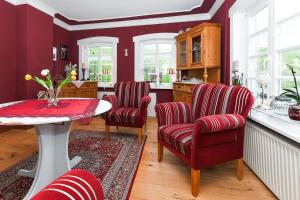 eine Küche mit roten Stühlen und einem Tisch in der Unterkunft Ferienwohnungen im Haus Hafenjuwel in Neuharlingersiel in Neuharlingersiel