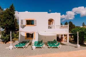 a group of lawn chairs and a house at Villa Can Vincent in Sant Josep de Sa Talaia