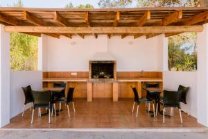 a patio with a table and chairs and a fireplace at Villa Can Vincent in Sant Josep de Sa Talaia