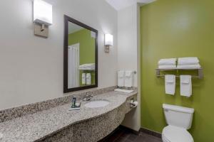 a bathroom with a sink and a toilet and a mirror at Sleep Inn & Suites Cave City in Cave City +41 photos