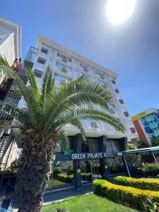 a palm tree in front of a building at Green Palmiye Hotel in Avcılar