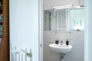 une salle de bain blanche avec un lavabo et un miroir dans l'établissement S303 - Sirolo, ampio trilocale in zona tranquilla, à Sirolo 43 autres photos