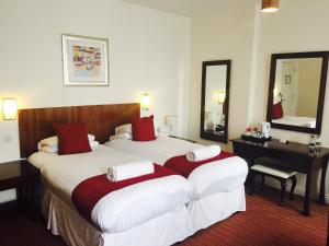 a hotel room with two beds and a desk at Park Central Hotel in Bournemouth
