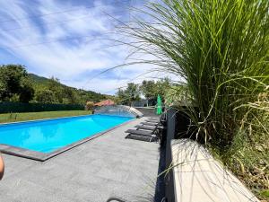 a swimming pool next to a patio with grass at Villa Diamond Hill in Sarajevo