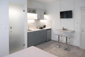 a white kitchen with a sink and a counter at four sis rooms in Mángana