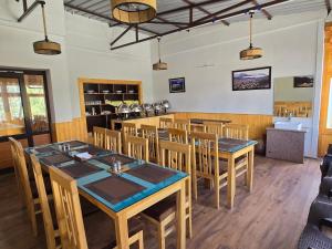 a dining room with wooden tables and chairs at Chalung House in Leh