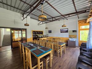 a dining room with wooden tables and chairs at Chalung House in Leh