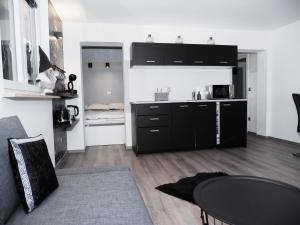 una cocina con armarios negros y una mesa en una habitación en Victoria's Place Apartment, en Liubliana