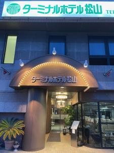 a building with a sign on the front of it at Terminal Hotel Matsuyama in Matsuyama