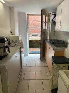 a kitchen with a sink and a door to a yard at Van Kim 2 - Souterrain Monteurwohnung in Emden +3 photos