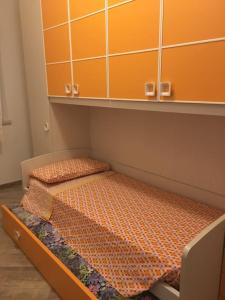 two beds in a room with orange cabinets at Everything a bike ride away! 10 mins to the beach with free parking! in Marina di Grosseto