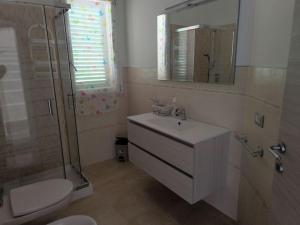 a bathroom with a sink and a shower and a toilet at Everything a bike ride away! 10 mins to the beach with free parking! in Marina di Grosseto +15 photos