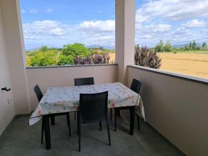 a table and chairs on a balcony with a view of a field at Everything a bike ride away! 10 mins to the beach with free parking! in Marina di Grosseto
