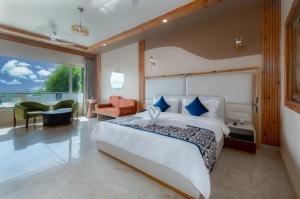 a bedroom with a large white bed and a large window at Grand Continent Morjim in Morjim +41 photos