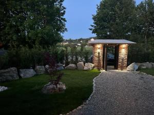 a garden with a brick arch with lights on the grass at Pensiunea Lorena in Bran