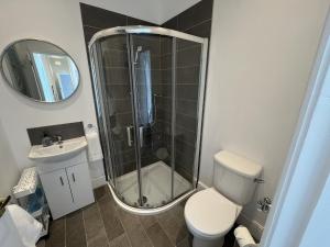 a bathroom with a shower and a toilet and a sink at Beachside Cottage Minehead in Minehead +20 photos