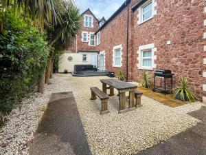 a bench in front of a brick building at Beachside Cottage Minehead in Minehead