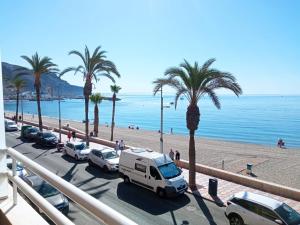 a white truck parked next to a beach with palm trees at El espigón de Aguadulce in Aguadulce
