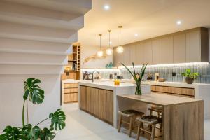 a kitchen with a large island with a table at Thalassophile Beach House - Heated Pool in St. Helena Bay