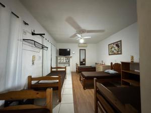 Habitación con sillas, mesas y ventilador de techo. en Pousada Anhanguera, en Ribeirão Preto