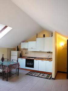 una cucina con mobili bianchi e un tavolo di Cannobio Medievale 4 a Cannobio