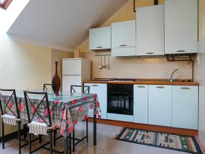 una cucina con mobili bianchi e un tavolo con sedie di Cannobio Medievale 4 a Cannobio