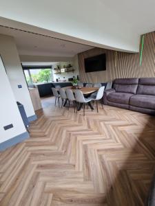 Una sala de estar con una mesa y sillas y un sofá. en Townhouse - 6 Bed Hot Tub House, en Bowness-on-Windermere