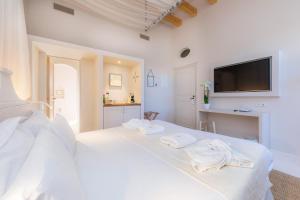 a white bedroom with a bed with towels on it at Yartan Boutique Hotel - Adults Only in Art&aacute;
