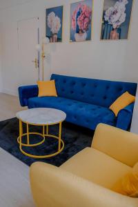 un salon avec un canapé bleu et une table dans l'établissement Résidence Peace, au Bourget