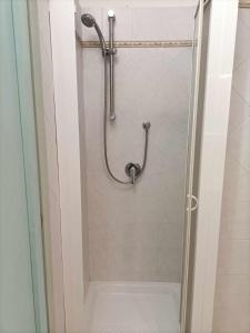 une douche avec une porte vitrée dans une salle de bain dans l'établissement La Muddizza appartement avec piscine, à Valledoria