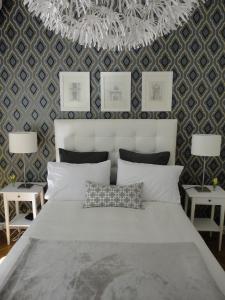 Apartamento en Recoleta في بوينس آيرس: غرفة نوم بسرير ابيض كبير مع طاولتين