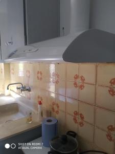 una cocina con fregadero y una capucha sobre una barra en DIAS APPARTMENT, en Artemida