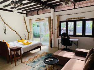 サムイ島にあるThe Summer House Samuiのベッドとソファとテーブルのある寝室