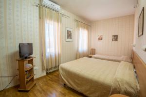 a bedroom with a bed and a tv in it at Albergo Ristorante Edo in Forlimpopoli