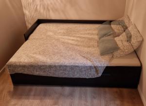 a small bed in a room with a wooden floor at Chambres d'hôtes Les Marmottes in Arbéost