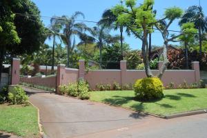a fence with a tree in a yard at Luxurious Room in excellent proximity to Beach in Ballito