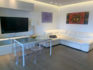 sala de estar con sofá blanco y mesa de cristal en FronteMare Luxury, en Montesilvano 5 fotos más